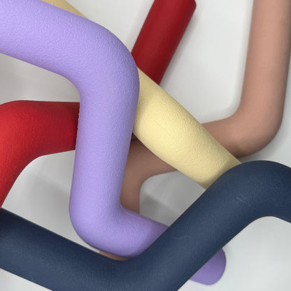 Hond speelt met roze, blauwe, rode, paarse, beige Speeltak van natuurlijk rubber – veilig alternatief voor de klassieke stok