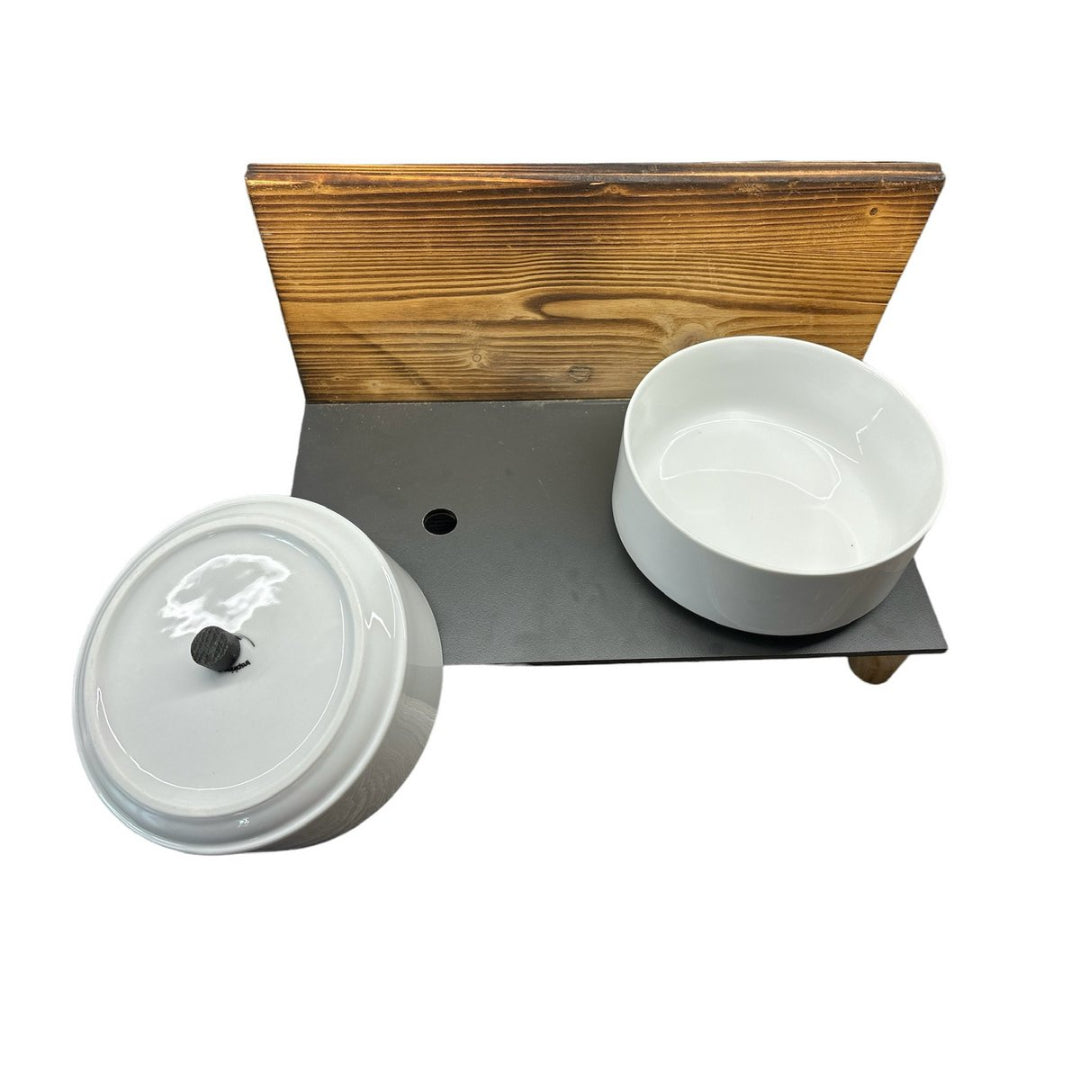 Verhoogd hondenvoerstation met porseleinen kommen en gevlamd houten achterwand