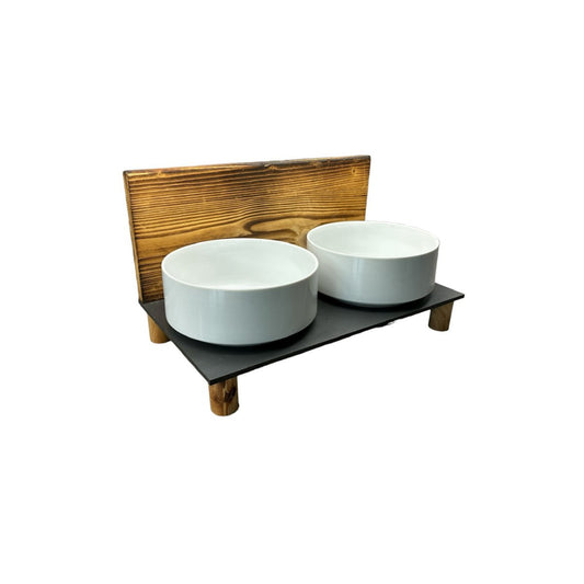 Verhoogd hondenvoerstation met porseleinen kommen en gevlamd houten achterwand